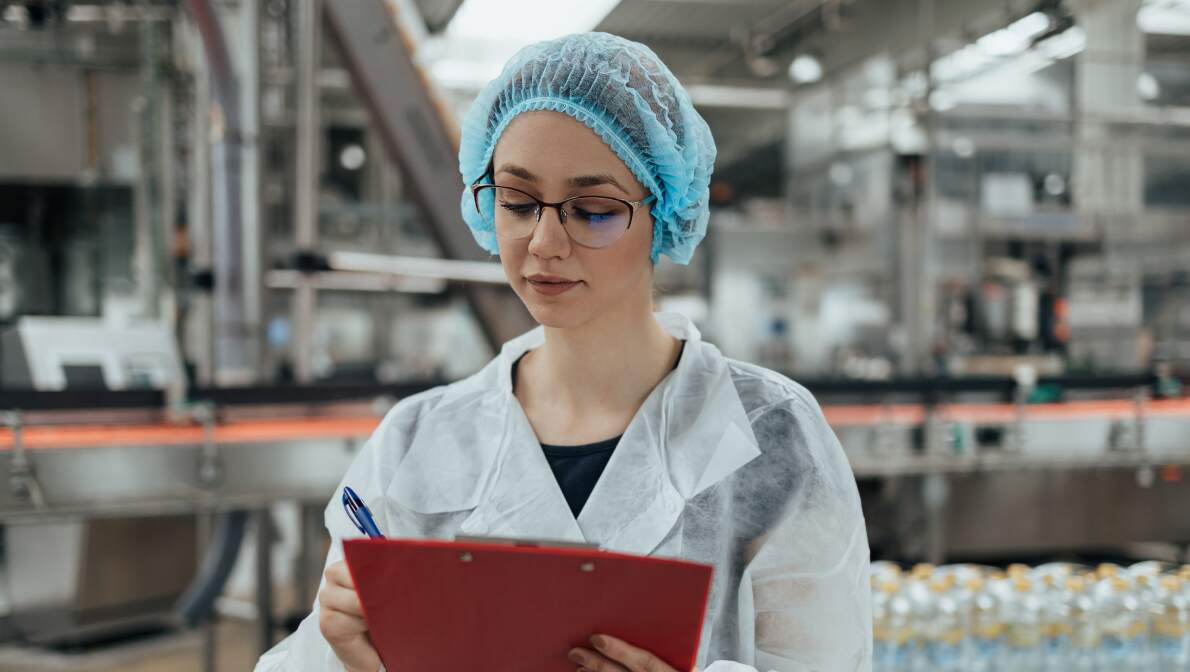 A professional quality assurance employee checking her chart.