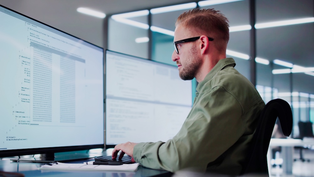 it recruiter in green shirt and glasses looking at screen